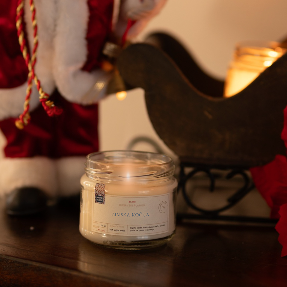 Mirisna sveća Zimska Kočija iz kolekcije Dunavski Plamen – ručno pravljena sojina sveća sa mirisom zime, toplinom doma i praznične magije, idealna za poklon i zimske večeri.